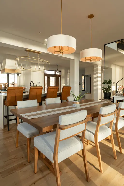 Salle à manger en aire ouverte — Rénovation Julien Dubé, entrepreneur général à Repentigny Salle à manger en aire ouverte avec grande table de bois, chaises capitonnées et deux suspensions blanches